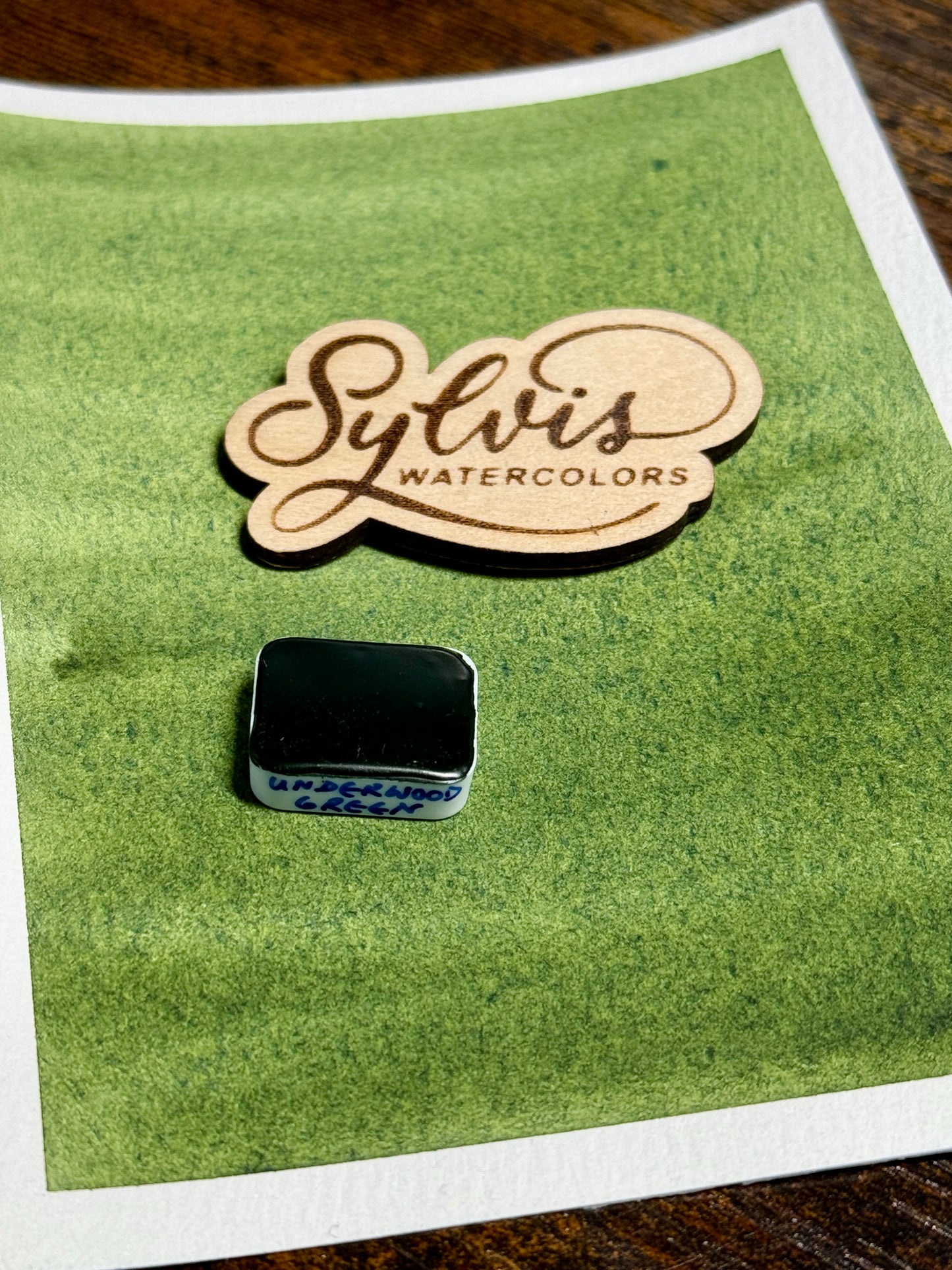 Farbswatch Underwoodgreen darauf Holzlogo und viertel Näpfchen mit Underwood Green