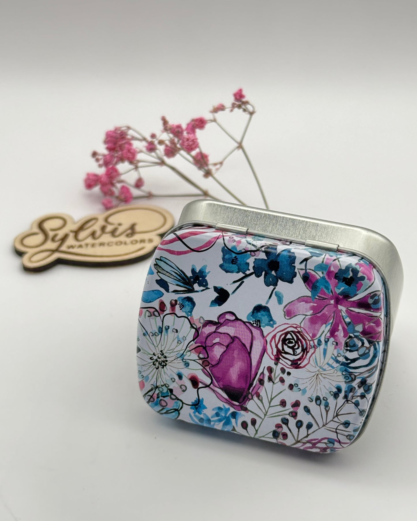 kleine Weißblechdose mit silbernem Unterteil und weißlackiertem Deckel mit modernem Blumenmuster in Türkis- und Magentatönen