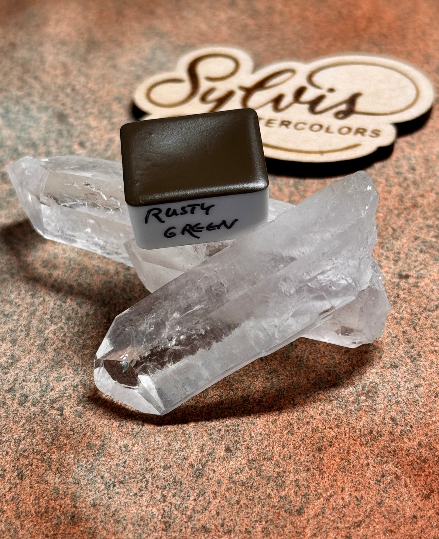 Halbes Näpfchen Rusty Green trappiert auf Bergkristall im Hintergrund Sylvis Watercolors Holzlogo