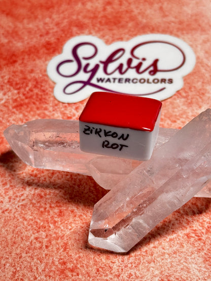 Halbes Näpfchen Zirkonrot auf Bergkristall trappiert im Hintergrund Logosticker Sylvis Watercolors
