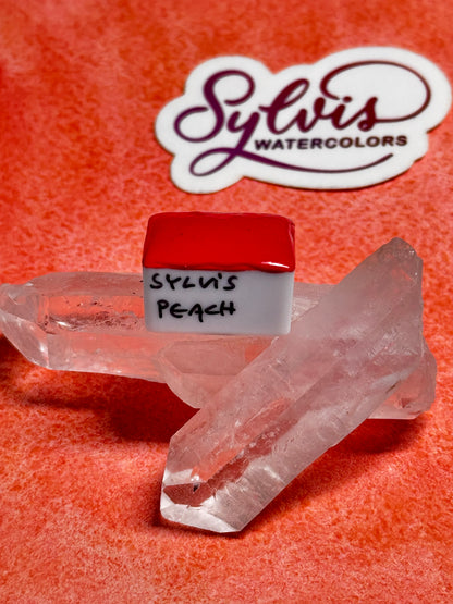Halbes Näpfchen Sylvi's Peach auf Bergkristall trappiert im Hintergrund Sylvis Watercolors Logosticker