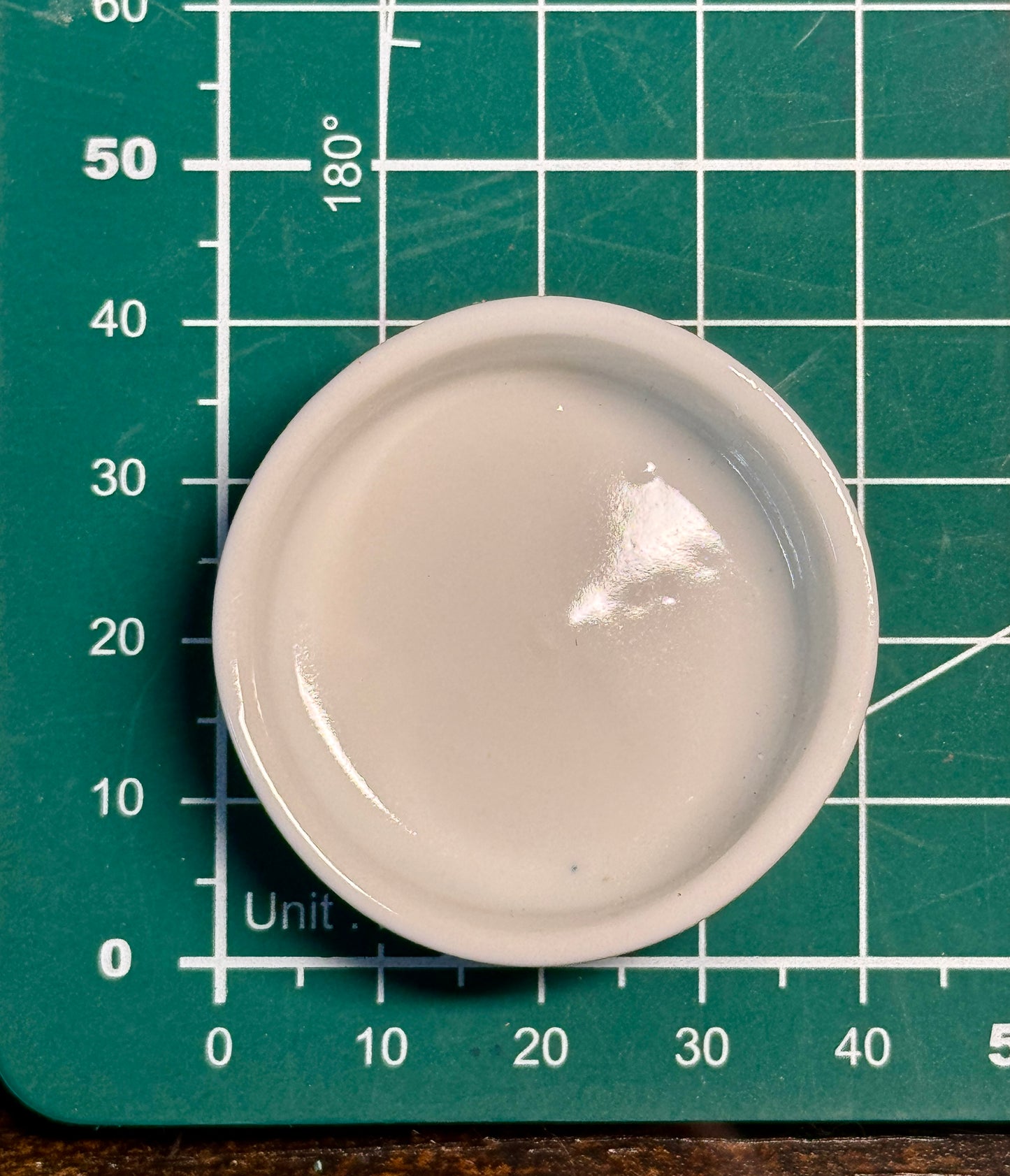 Rundes Keramiknäpfchen Draufblick auf grüner Schneidematte mit Zentimetereinteilung zum Darstellen der Abmaße