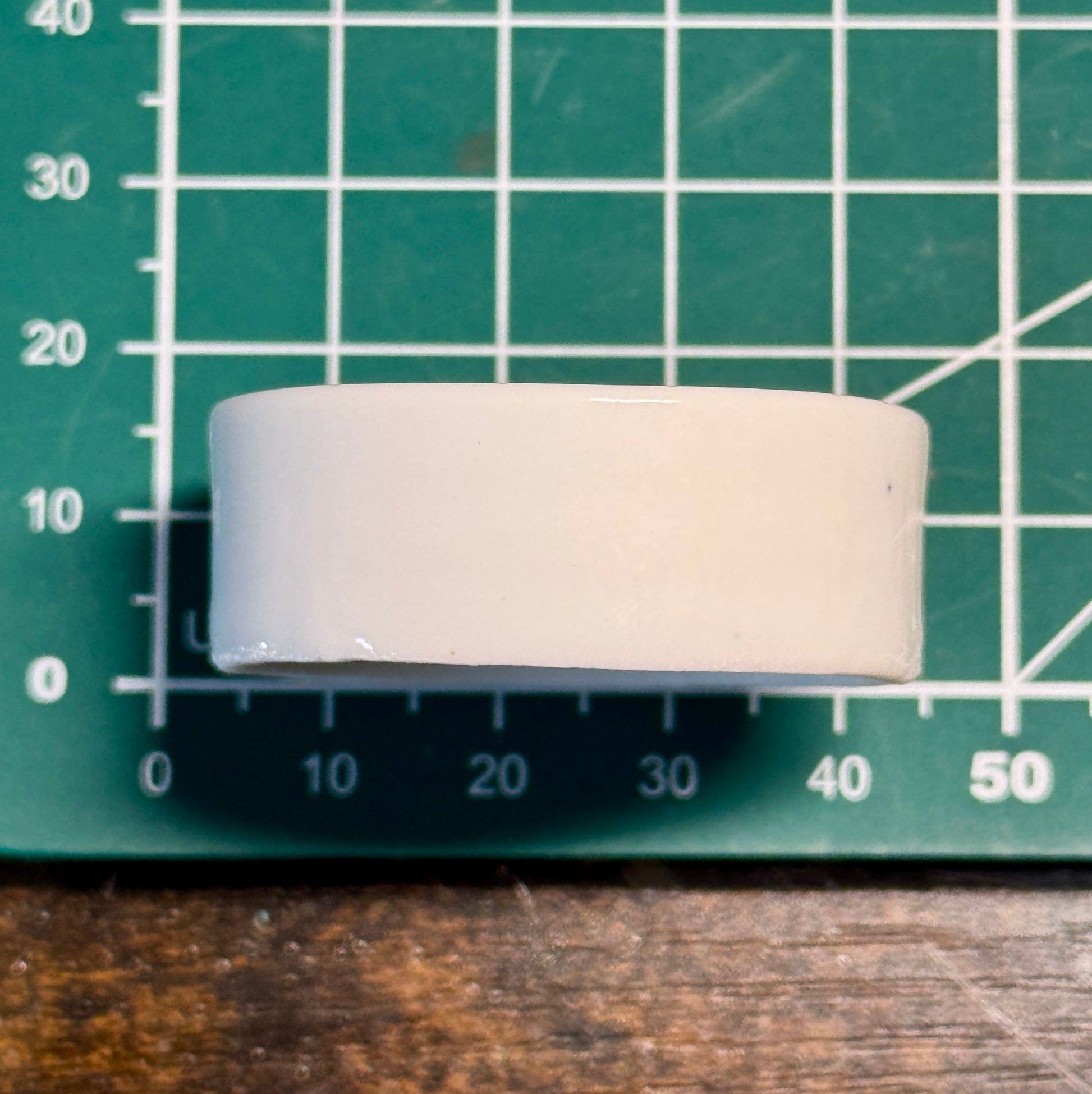 Rundes Keramiknäpfchen hochkant auf grüner Schneidematte mit Zentimetereinteilung zum Darstellen der Abmaße