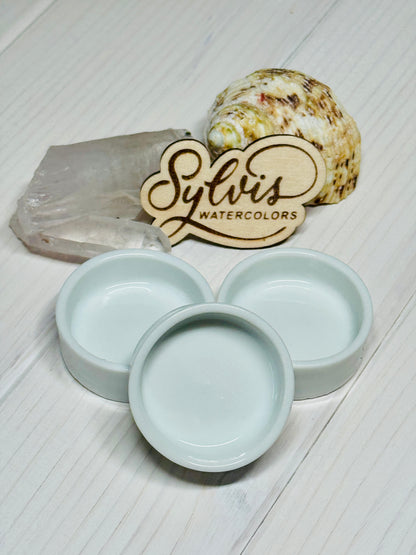 runde Keramiknäpfchen vor Holzlogo und Dekoelemten Bergkristall sowie Schneckenhaus