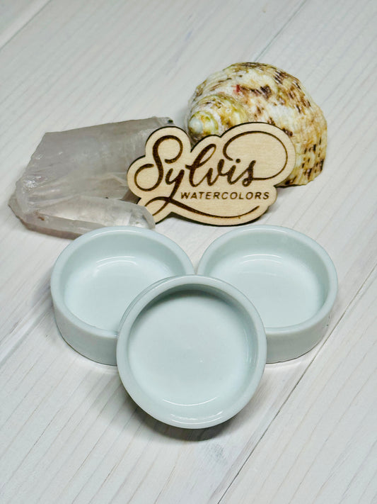 runde Keramiknäpfchen vor Holzlogo und Dekoelemten Bergkristall sowie Schneckenhaus