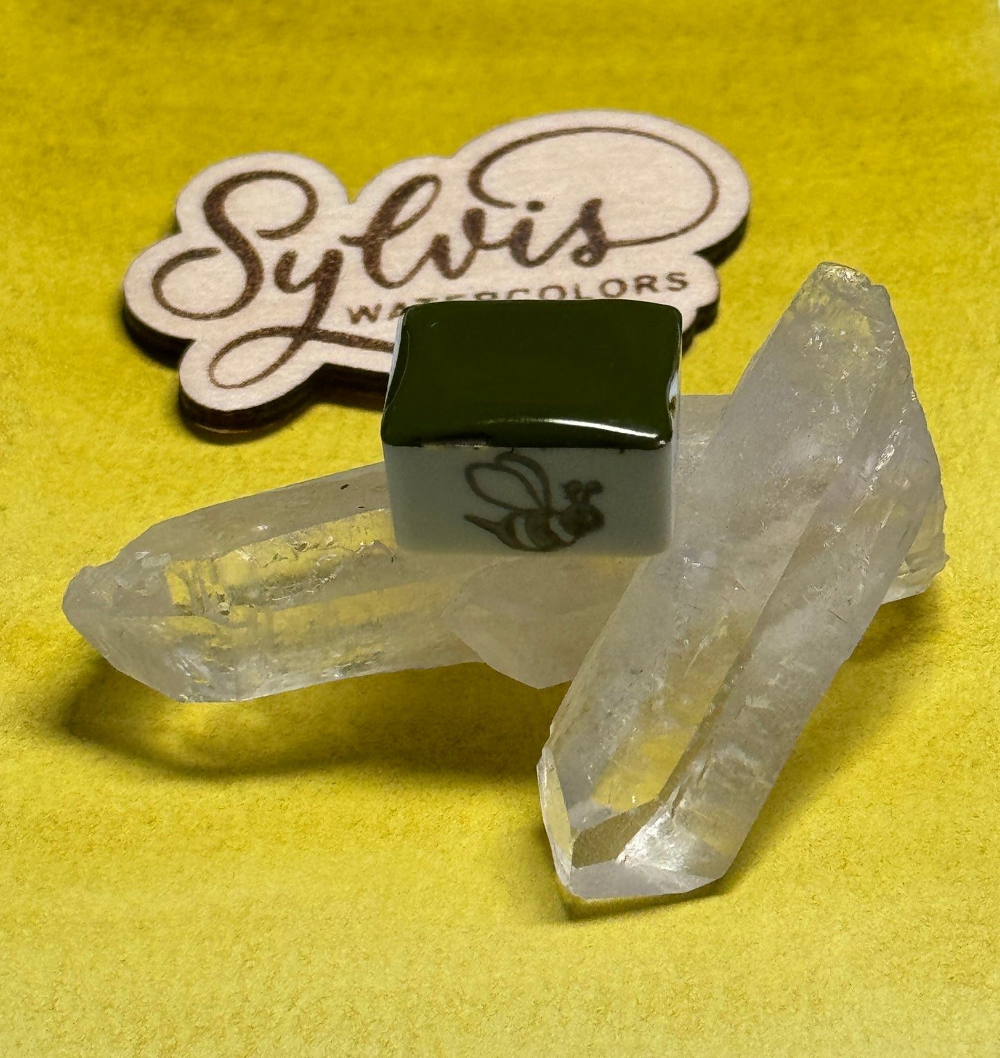 Halbes Näpfchen Sylvi's Greengold auf Bergkristall deokoriert mit Holzlogo Sylvis Watercolors im Hintergrund
