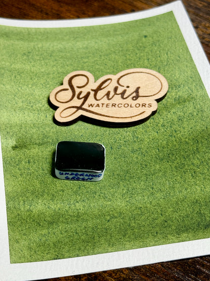 Farbswatch Underwoodgreen darauf Holzlogo und viertel Näpfchen mit Underwood Green