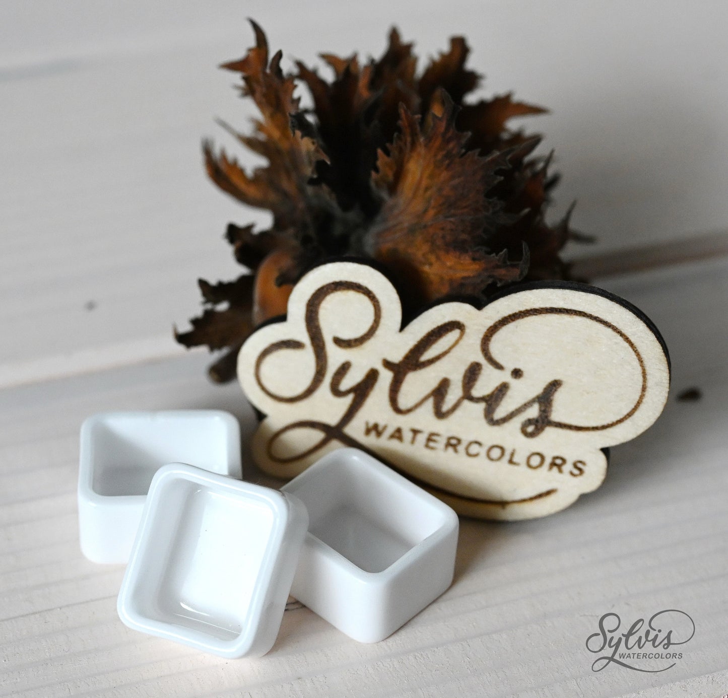 halbe Näpfchen aus glasierter Keramik im Hintergrund Holzlogo und Deko