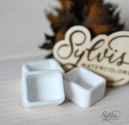 Nahaufnahme  halbe Näpfchen aus glasierter Keramik im Hintergrund Holzlogo und Deko