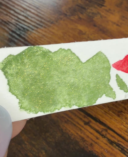 Farbswatch von Temple Green und Temple Ember auf Aquarellpapierstreifen, als Video, um in Bewegung den Glitzereffekt zu zeigen